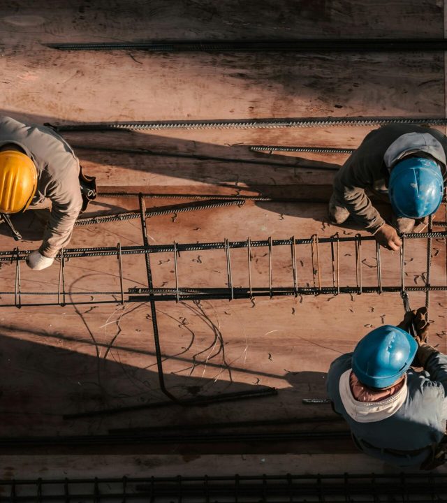 Top view of workers in hard hats assembling steel bars on a construction site in Buenos Aires.